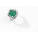 Emerald and Diamond Dress Ring, the Step-Cut Emerald to a Bifurcated Shoulder Surround Set with