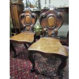Pair of William IV Carved Mahogany Hall Chairs with Scrolled Decoration above Shaped Supports