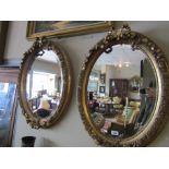 Pair of Gilded Oval Mirrors with Upper Ribbon Motif Decorations Each 31 Inches High Approximately