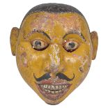 A PAINTED WOOD RITUAL MASK, INDIA, 19TH CENTURY carved with protruding teeth and viewing slits below