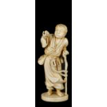 ˜A JAPANESE IVORY OKIMONO OF A YOUNG MAN, MEIJI PERIOD, LATE 19TH CENTURY standing in windswept