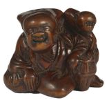 A JAPANESE WOOD NETSUKE OF A SARUMAWASHI, EDO PERIOD, CIRCA 1790 the monkey going to steal a