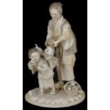 ˜A JAPANESE IVORY OKIMONO OF A WOMAN AND CHILDREN, MEIJI PERIOD (1868-1912) carved with a child with