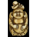 ˜A JAPANESE STAINED IVORY NETSUKE OF HOTEI WITH A CHILD ON HIS HEAD, EARLY TAISHO PERIOD, CIRCA 1920