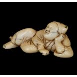 ˜AN IVORY NETSUKE OF A SLEEPING MONKEY TRAINER, EDO PERIOD, 18TH CENTURY lying beside a small basket