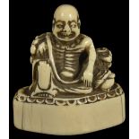 ˜A JAPANESE IVORY TOBORI NETSUKE OF A RAKAN, MID EDO PERIOD, CIRCA 1700 the ascetic seated leaning