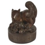 A JAPANESE WOOD SEAL NETSUKE OF A SQUIRREL, LATE EDO PERIOD, CIRCA 1850 beside a bunch of grapes