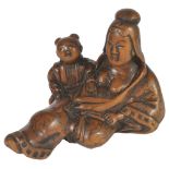 A JAPANESE WOOD NETSUKE OF A COURTESAN AND BOY, LATE EDO PERIOD, CIRCA 1820 her Chinese style robe