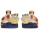 AN OPPOSING PAIR OF STAFFORDSHIRE FLAT-BACK GROUPS OF DOGS WITH PUPS IN BASKETS, CIRCA 1850 each