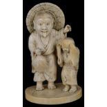 ˜A JAPANESE IVORY OKIMONO OF AN ONI AND BOY, MEIJI PERIOD (1868-1912) the oni dressed in robes and