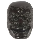 ˜A JAPANESE EBONY MASK NETSUKE OF A FIERCE ONI, LATE EDO PERIOD, CIRCA 1820 unsigned 5.1cm high