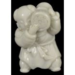 A JAPANESE HIRADO WHITE PORCELAIN NETSUKE OF A KARAKO, LATE EDO PERIOD, CIRCA 1850 the Chinese boy