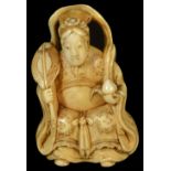 ˜A JAPANESE IVORY NETSUKE OF SEIOBO, LATE EDO PERIOD, CIRCA 1860 seated on a stool and holding a