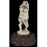 ˜A JAPANESE IVORY OKIMONO OF WRESTLERS, MEIJI PERIOD (1868-1912) carved as one wrestler throwing his