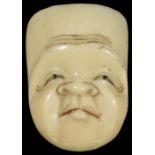 A JAPANESE TOOTH NETSUKE OF A MALE MASK, EARLY 20TH CENTURY the eye pupils and lips pigmented,
