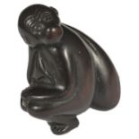 A JAPANESE WOOD NETSUKE OF A MONKEY WITH SACK OVER ITS SHOULDER, LATE EDO PERIOD, CIRCA 1830