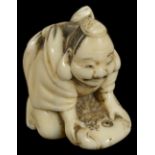 ˜A JAPANESE WALRUS IVORY NETSUKE OF EBISU, MEIJI PERIOD (1868-1912) the lucky god holding down a