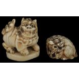 ˜TWO JAPANESE IVORY NETSUKE OF SHISHI, 18TH AND 19TH CENTURY one a study of a shishi crouched and