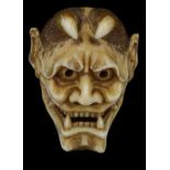 ˜A JAPANESE IVORY MASK NETSUKE OF HANNYA, MEIJI PERIOD (1868-1912) typically carved with bared