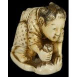 ˜A JAPANESE IVORY NETSUKE OF A MAN POLISHING, EARLY MEIJI PERIOD, CIRCA 1880 down on his knees