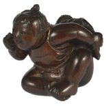 A JAPANESE WOOD NETSUKE OF A CHILD DOING BEKKAKO, LATE EDO PERIOD, CIRCA 1860 hiding a hozuki (