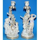 A pair of 19th century Meissen candlesticks in the rococo manner, the scroll and leaf columns with