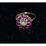 A 9 carat hallmarked gold dress ring with garnets in flower head setting, 2.4