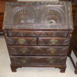 A Georgian oak fall front bureau with extensive carving, fitted interior, 2 long and 2 short