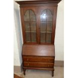 A 1930's oak bureau/bookcase the upper section enclosed by 2 glazed doors, fall front and 2 drawers