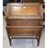 A 1930's golden oak fall front bureau with blind fret decoration