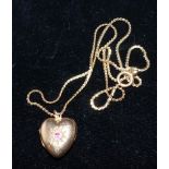 A yellow metal heart shaped locket set with diamond chips and an amethyst, on chain stamped '9CT',