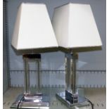 A pair of chrome and glass table lamps with shades