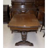 A 1930's oak heavily carved dining suite on bulbous legs, comprising draw leaf table, 2 chairs and