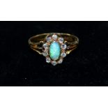 A ladies dress ring set with an oval opal surrounded by 10 diamonds, marks worn, tests as 18