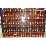 A collection of souvenir spoons with display rack