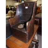 An 18th/19th century child's stained wood commode chair in the form of a lambing chair