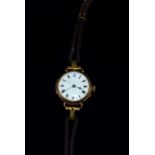 An Edwardian ladies 9 carat hallmarked gold wristwatch with gilded white enamel dial