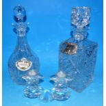 A Swarovski crystal table candle holder, 2 cut glass decanters, a silver wine label and another
