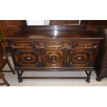 A 1930's Jacobean style oak sideboard of 3 cupboards and 3 drawers