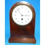 An Edwardian inlaid figured mahogany arch top mantel clock with white enamel dial and French drum