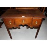 An 18th century country made oak lowboy with 3 frieze drawers, shaped apron and square chamfered