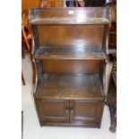 A reproduction oak bookcase with cabinet under