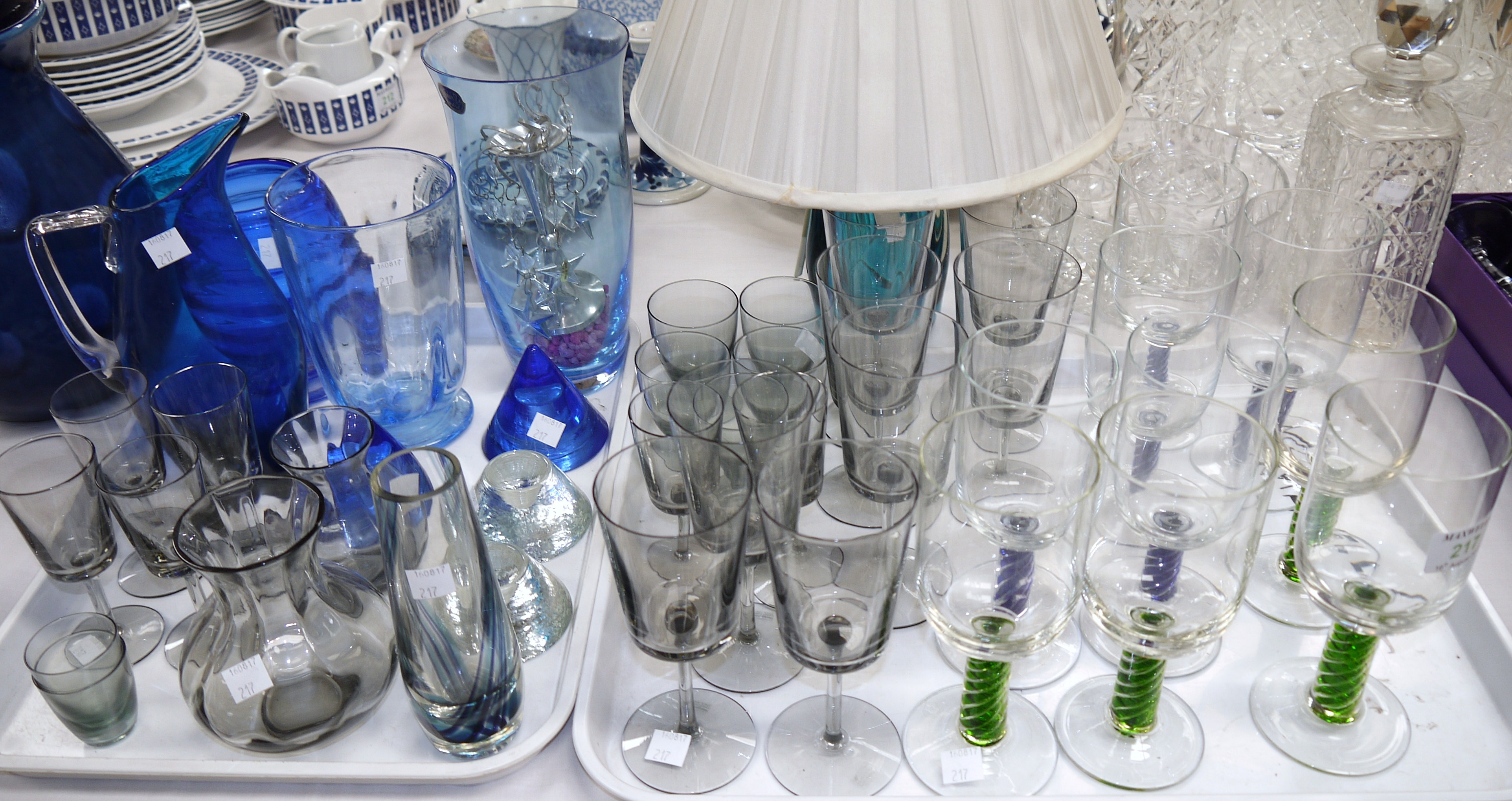 A set of four green and five blue wine glasses with coloured air twist stems and a selection of