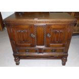 An oak Jacobean style side cupboard with 2 panel doors and 2 drawers; a similar bedside cabinet