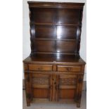 A Jacobean style oak dresser with rack over double cupboard and double drawers, width 37"