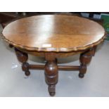 An oval oak scalloped occasional table on bulbous legs