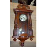 A 19th century spring driven Vienna wall clock with arched finial and turned side column, striking