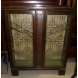 A 1930's oak display cabinet enclosed by 2 glazed doors