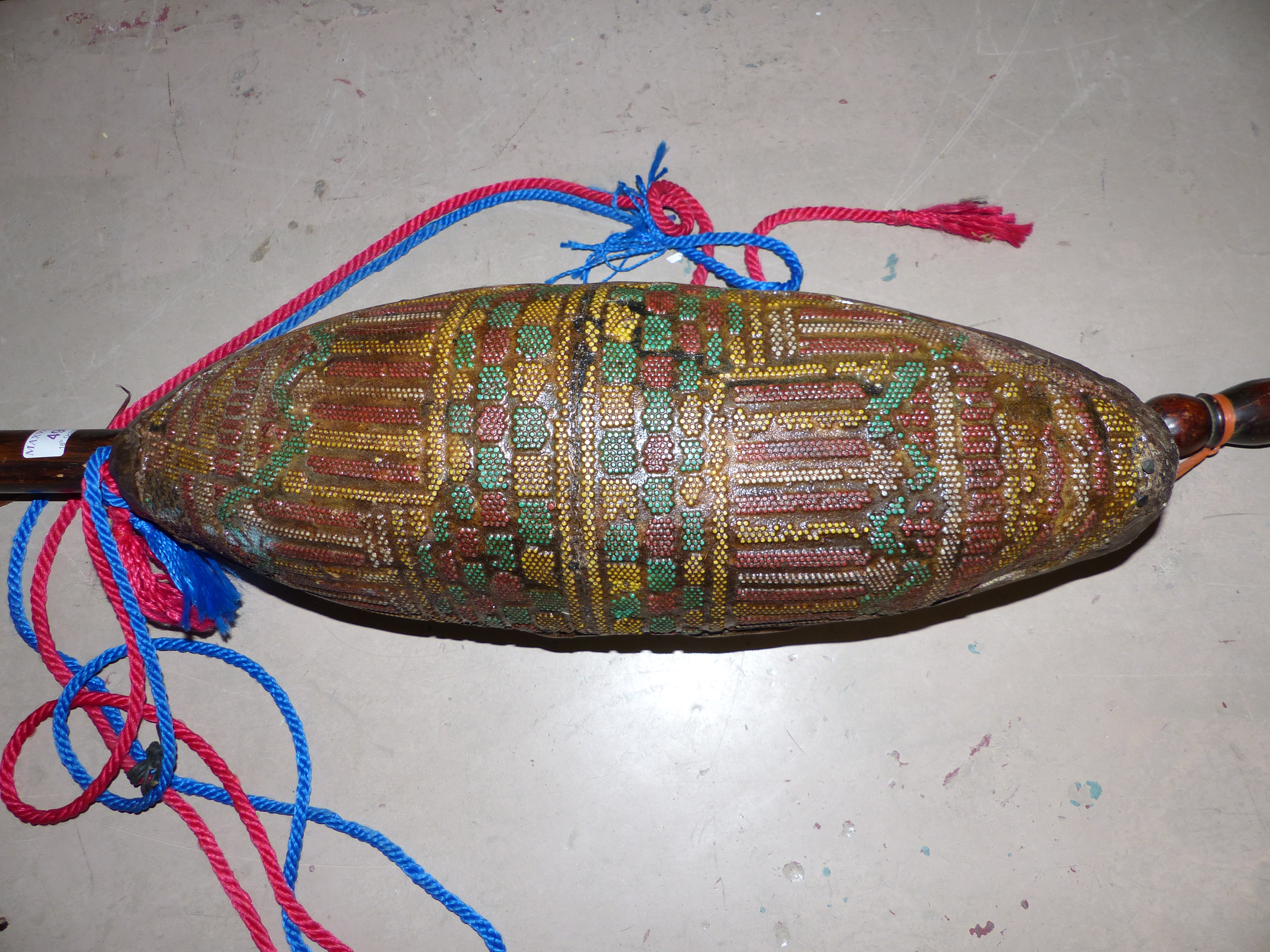 An unusual musical instrument with 3 strings and beaded decoration to the body and vellum cover