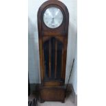 A 1930's oak arch top longcase clock with glazed door and triple weight driven chiming movement